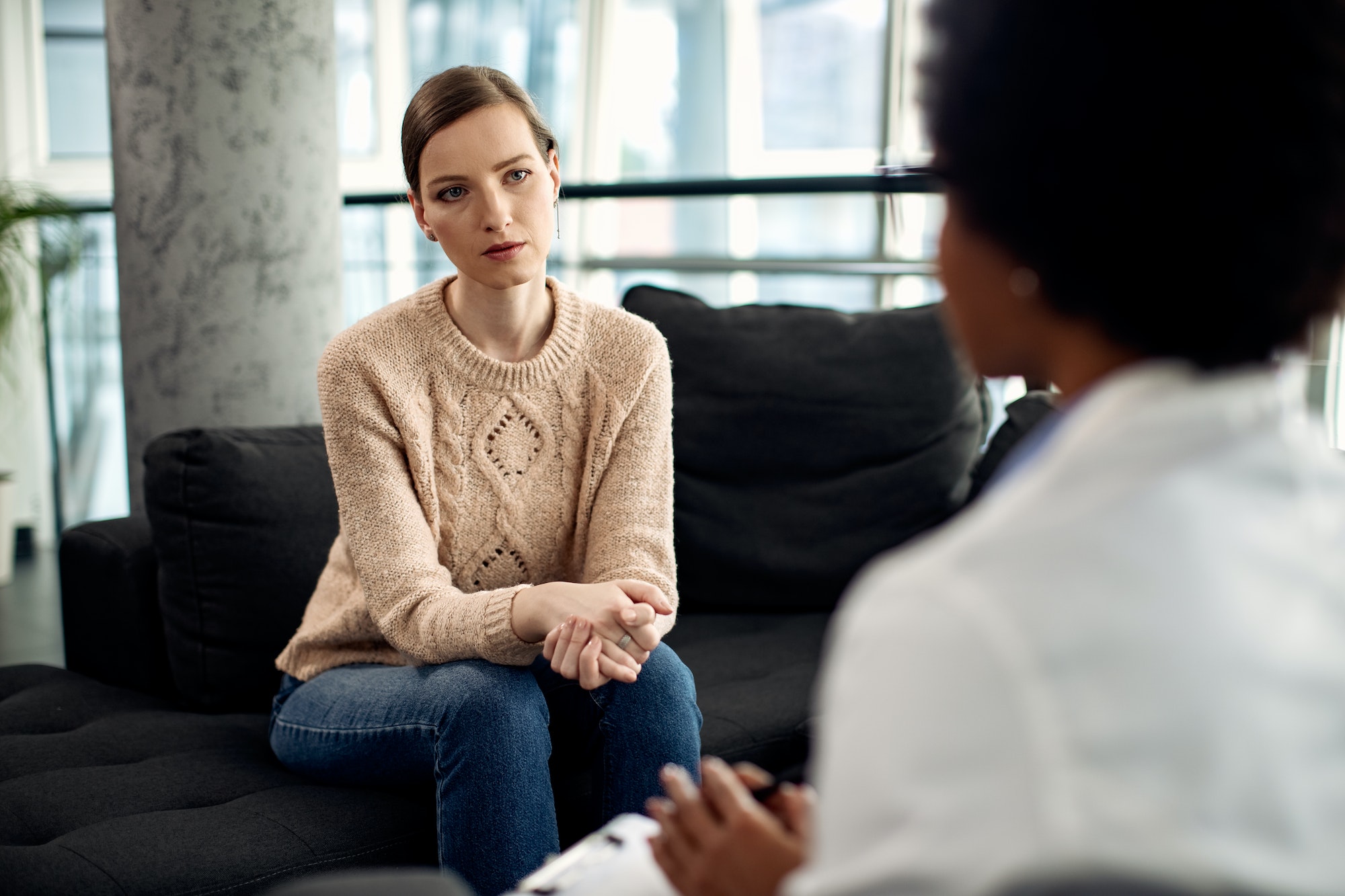 Young woman having counseling with psychotherapist at doctor's office.
